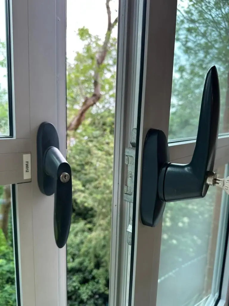 Open aluminium window with black locking handles